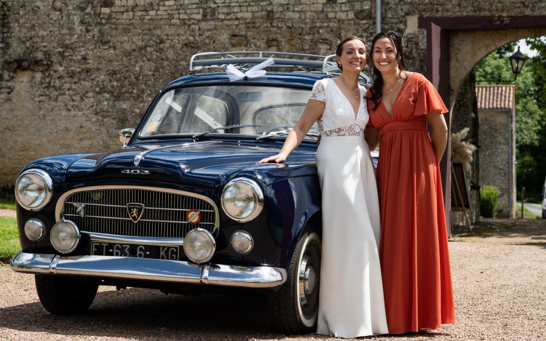 Ameline Blot et sa sœur posant devant une voiture de collection lors d'un mariage, exemple de photographie de mariage pour professionnels.